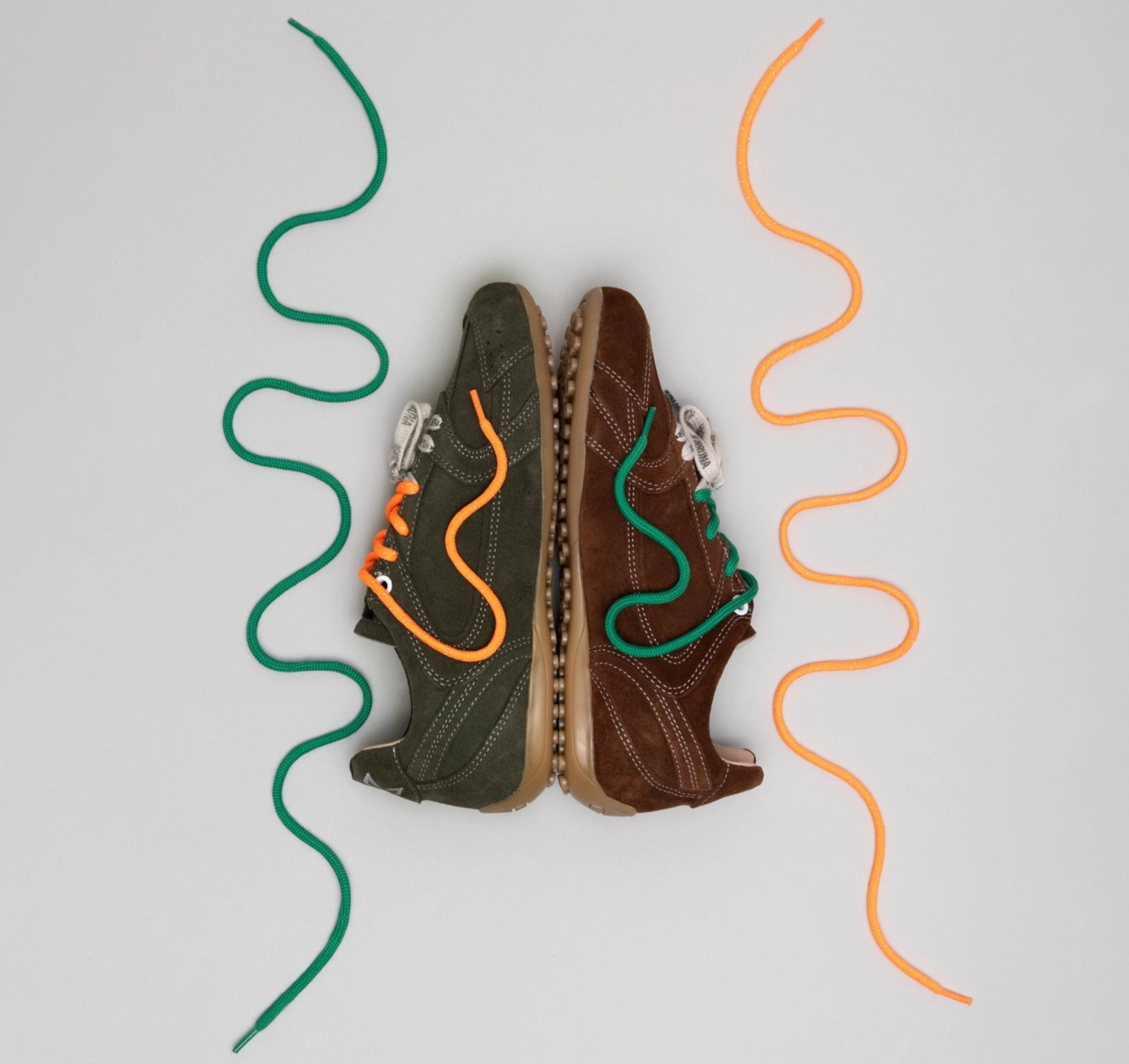 Two pairs of shoes with colorful laces on a light gray background